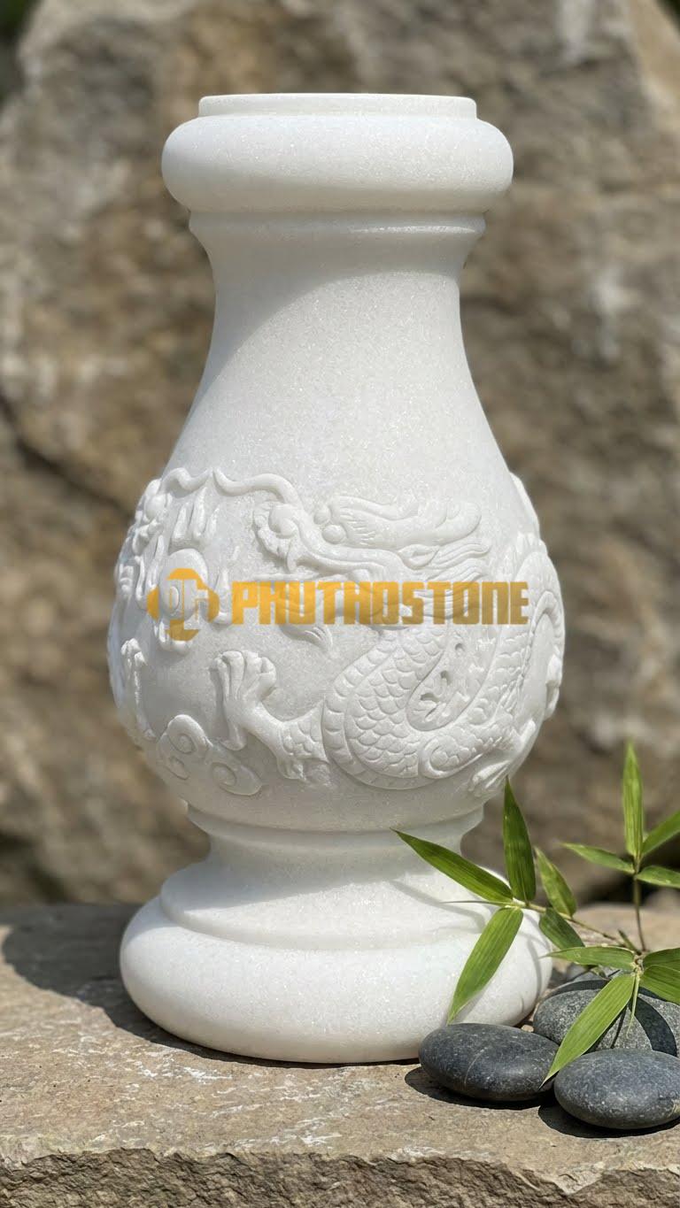 Con Tiện Đá Trắng Muối Lục Bình Chạm Rồng: Dáng lục bình, cao 80cm, đk 16cm, thân bình chạm nổi rồng cuộn (Long cuốn) tinh xảo.